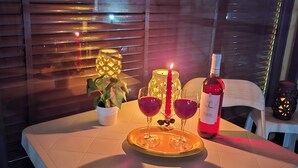 Ein Tisch mit einer Flasche Rotwein, zwei Gläsern und einer Kerze.