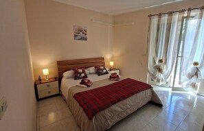 A bedroom with a bed, nightstands, a red plaid blanket, and a window with curtains. - Sea & Mountains Apartment (Mascali)