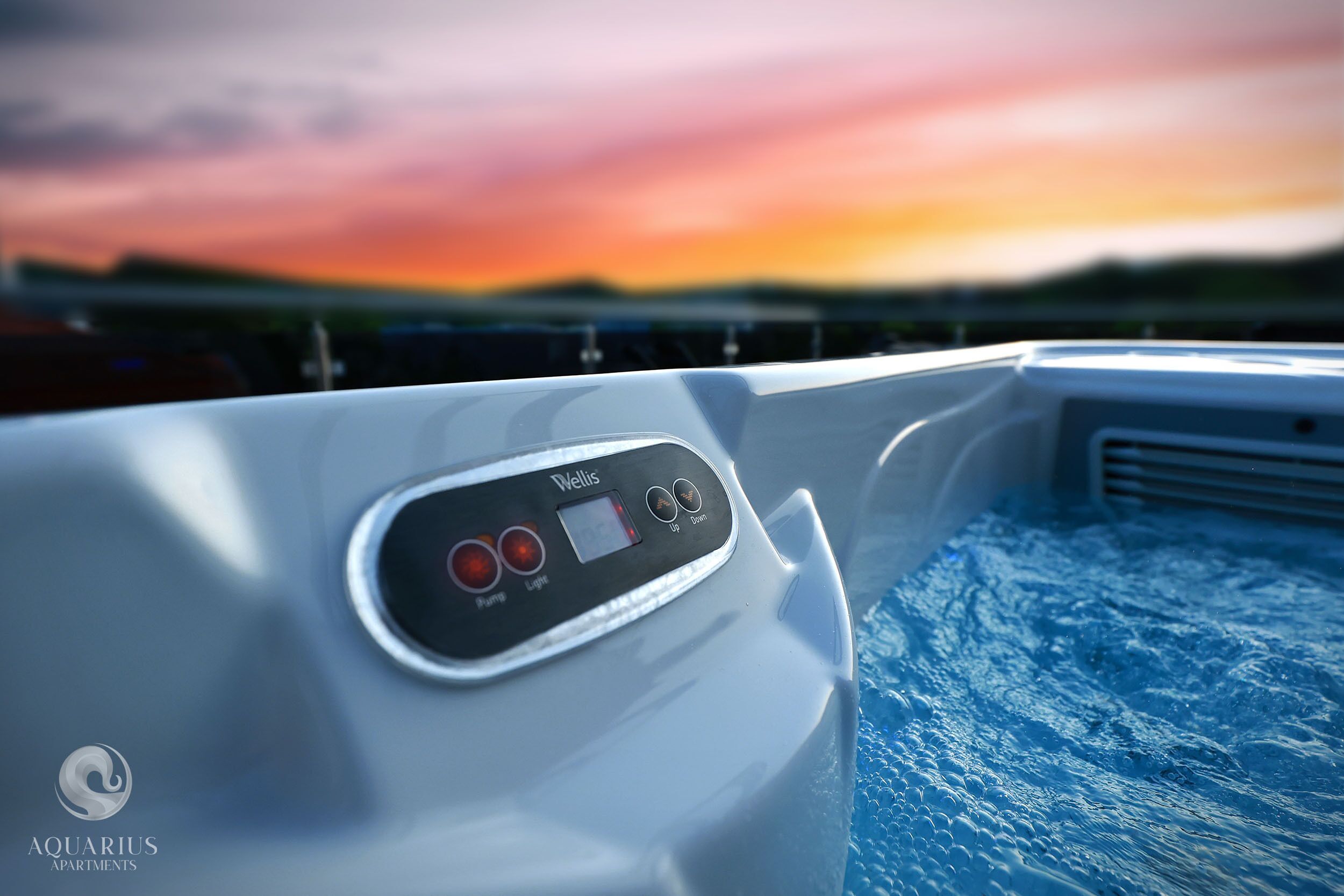 Panel de control con botones etiquetados 'Bomba', 'Luz' y 'Arriba/Abajo' en un ambiente junto a la piscina.