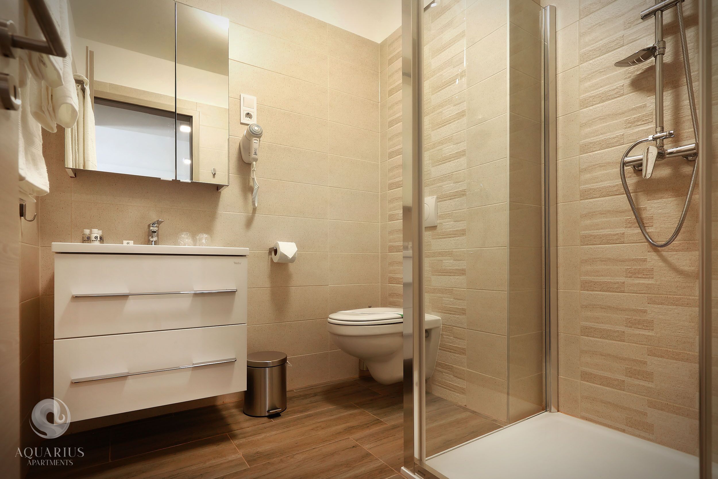 Ein modernes Badezimmer mit Duschkabine aus Glas, Waschbecken in Weiß und Toilette.