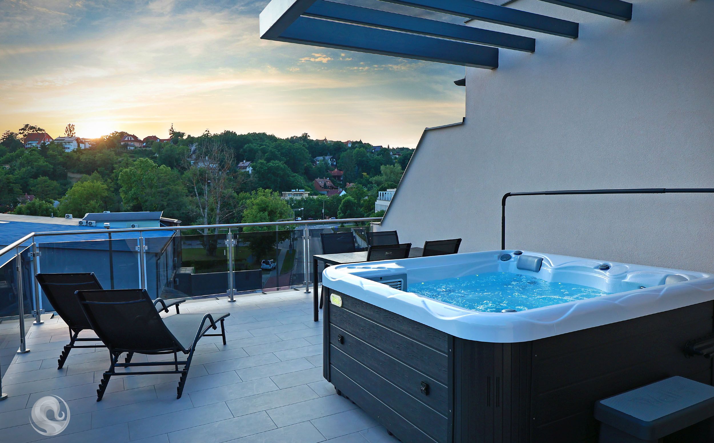 Eine Dachterrasse mit Whirlpool, Liegestühlen und Blick auf die Umgebung.