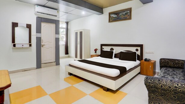 Un dormitorio moderno con una cama grande, una mesita de noche, un armario y un sofá estampado.