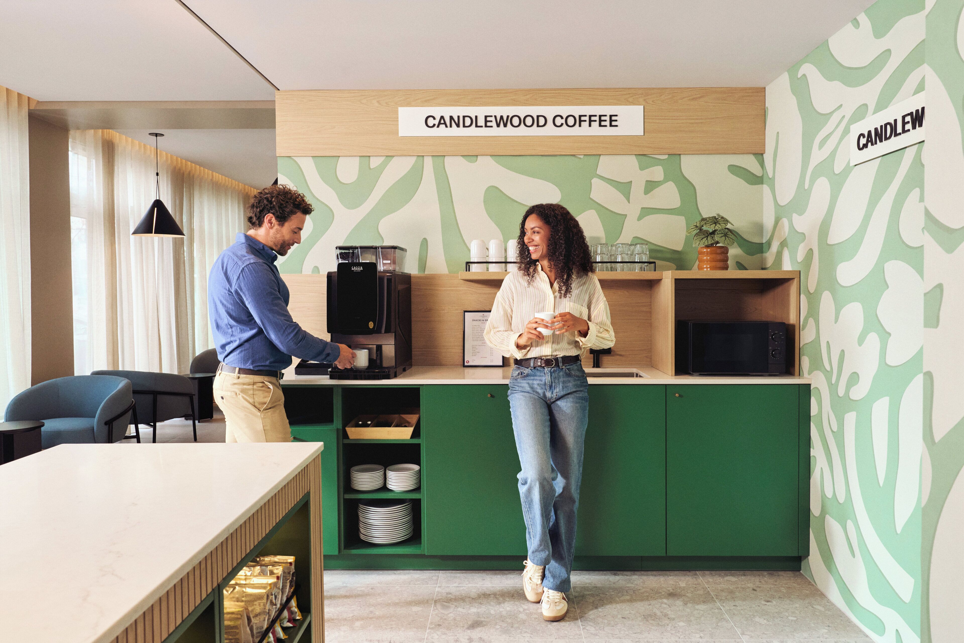 A coffee shop interior with a coffee machine, a menu board, and a counter.
