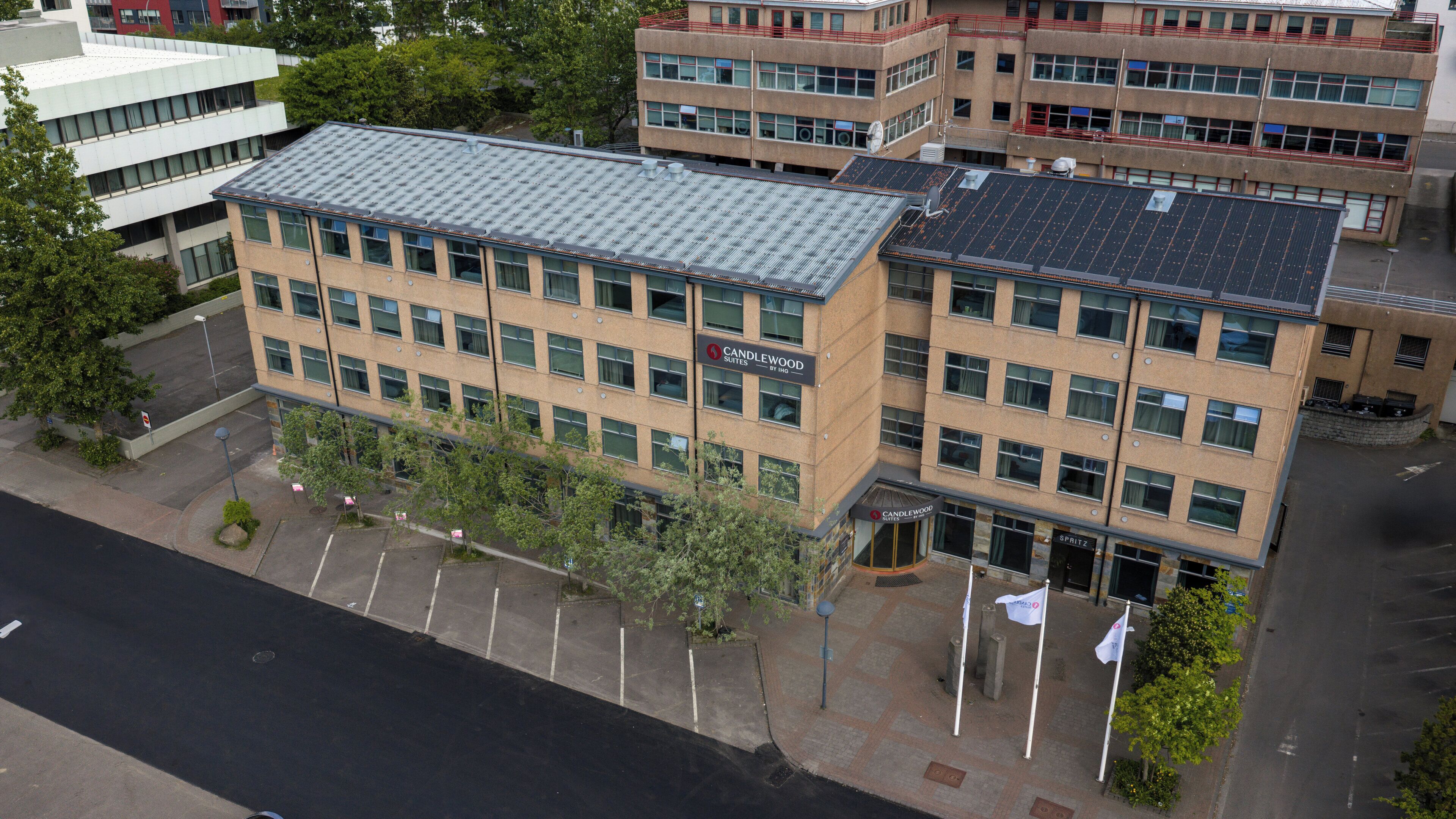 Un edificio de varios pisos con techo plano, ventanas amplias y un letrero de Candlewood Suites by Inn.
