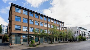 Un immeuble à plusieurs étages, doté d’une façade en briques, de grandes fenêtres et d’un toit plat.
