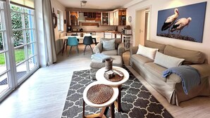 Ein modernes Wohnzimmer mit einer Couch, einem Couchtisch und einem Gemälde von Störchen.