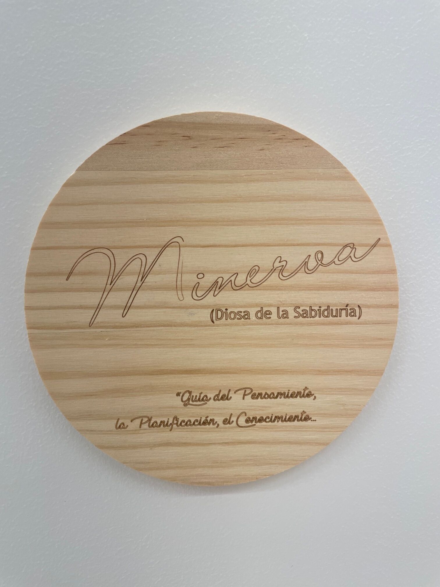 A circular wooden plaque with engraved text.