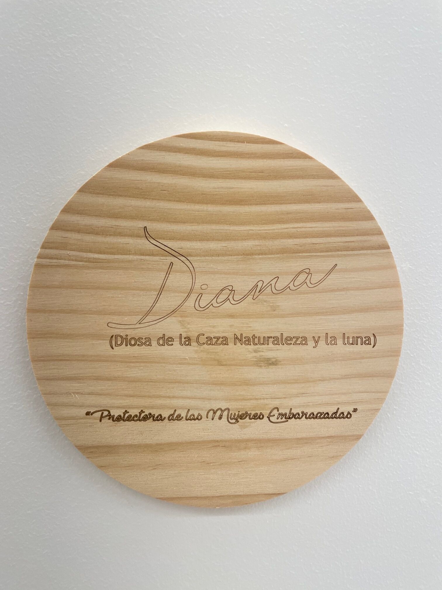 Una placa de madera circular con texto grabado.