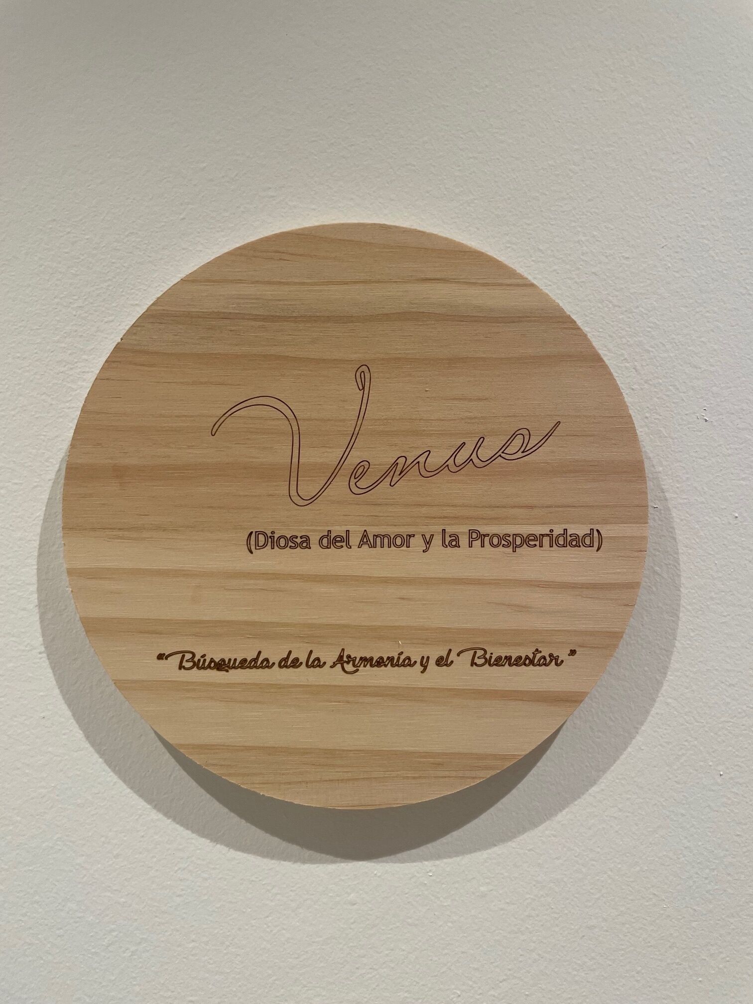 Una placa de madera circular con texto grabado.