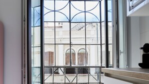 Une cuisine moderne dotée d’une grande fenêtre offrant une vue sur le paysage urbain.