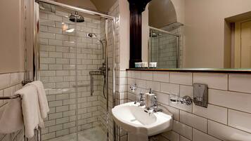 A bathroom with a glass-enclosed shower, a white sink, and a mirror above the sink.