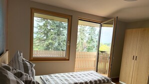 A bedroom with a bed, a window, and a wardrobe. - Family-friendly vacation apartment - four-legged friends also welcome! (Binzen)
