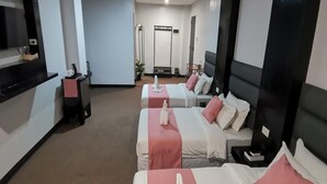 Una habitación de hotel con dos camas, televisor, escritorio y espejo.