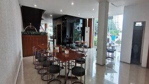 Un comedor moderno con una mesa de madera y sillas metálicas, una escalera y vista a la calle.