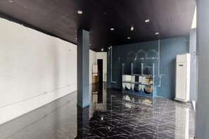 Ein moderner Hotelkorridor mit glänzendem schwarzen Boden, weißen Wänden und dunkler Decke.