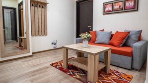 A modern living room with a grey sofa, wooden coffee table, and a mirror. - Apartment Tbilisi (Tbilisi)