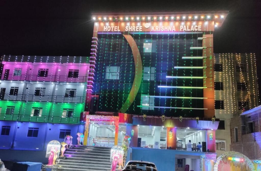 Un hôtel appelé « Hotel Shree Krishna Palace », doté d’une façade moderne et d’une enseigne lumineuse.