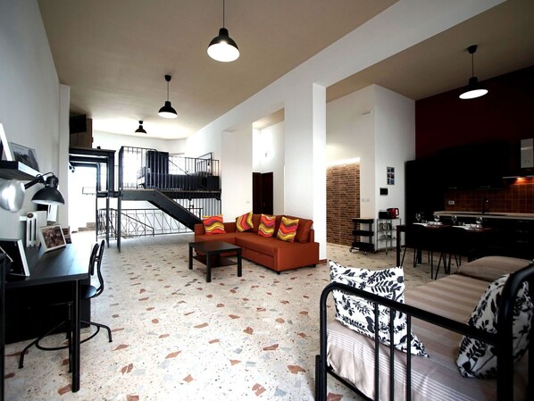 Amplia sala de estar con sofá, mesa de comedor y área de cocina.