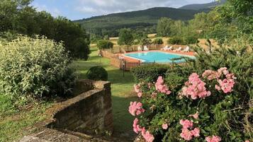 Una piscina al aire libre de temporada, sillones reclinables de piscina