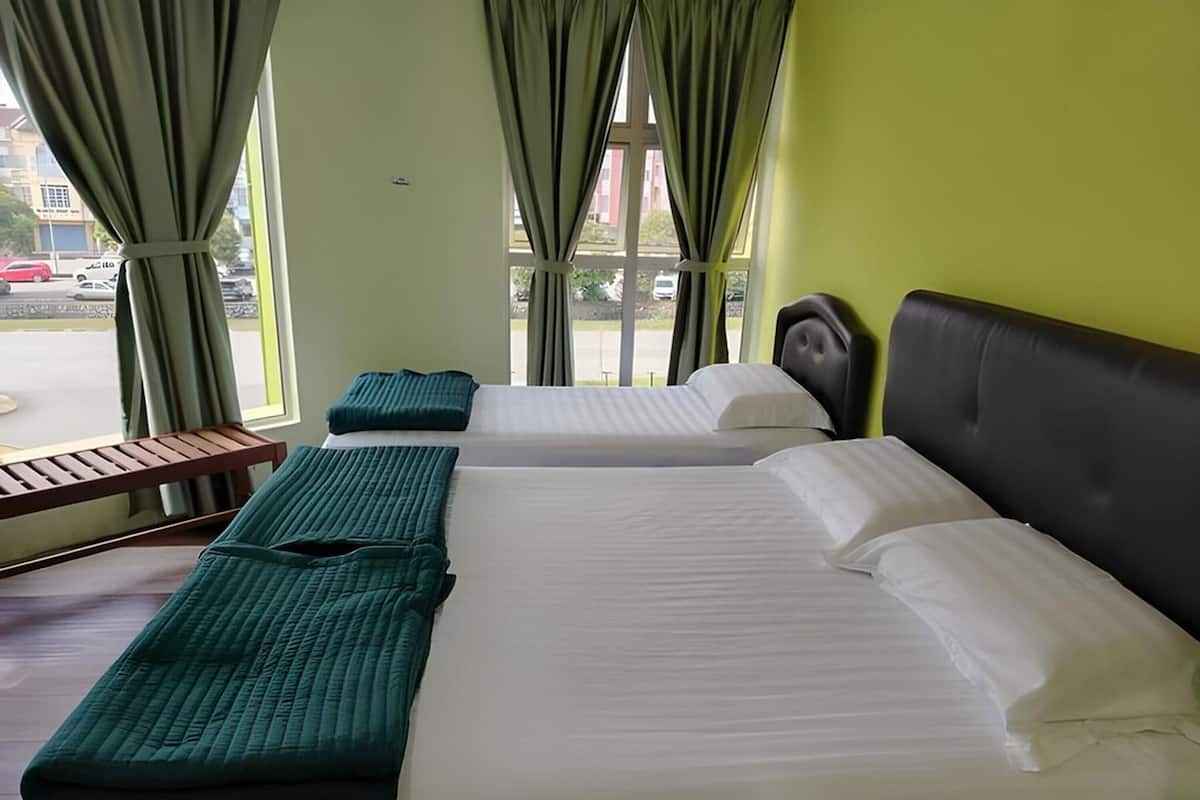 A hotel room with two beds, a bench, and large windows with curtains.
