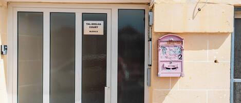 A building entrance with a sign reading "TAL-MIELHA COURT BLOCK B".