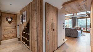 A modern interior with wooden walls, a staircase, and a large window offering a view of the outdoors.