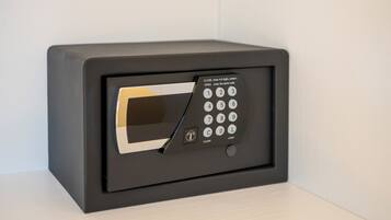 A black safe with a keypad and a small screen, featuring instructions for opening and closing.