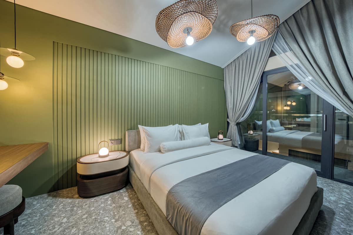A modern bedroom with a large bed, bedside tables, and a seating area.
