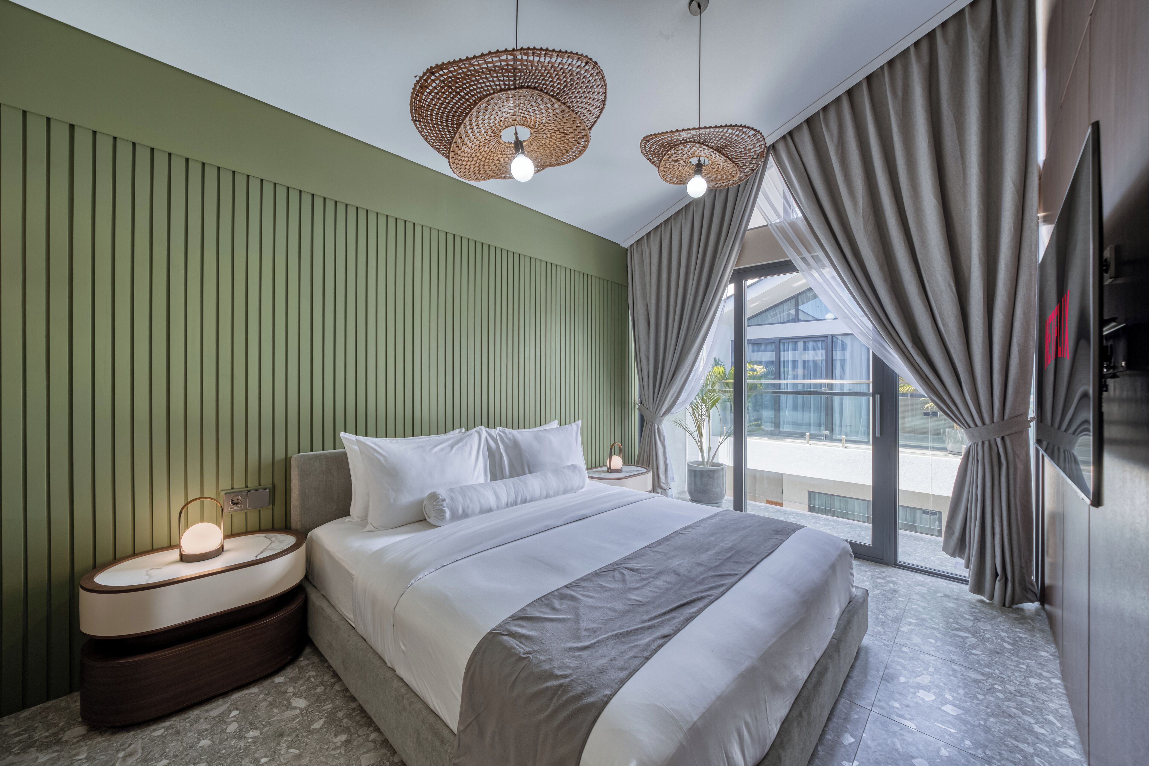Un dormitorio moderno con cama, mesita de noche y un amplio ventanal con cortinas.