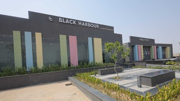 A modern building with the sign "BLACK HARBOUR" and "FOOD STAYS" indicating a restaurant or dining area.