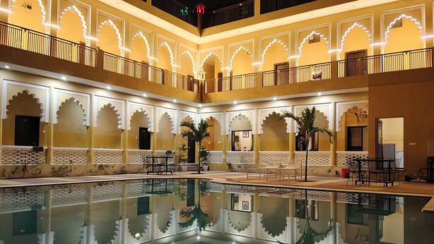 Ein Innenhof mit Pool, verzierten Bögen und Sitzbereichen.