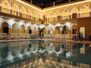 A courtyard with a pool, ornate arches, and seating areas. - L S Haveli - A Heritage Lake View Haveli (Pushkar)