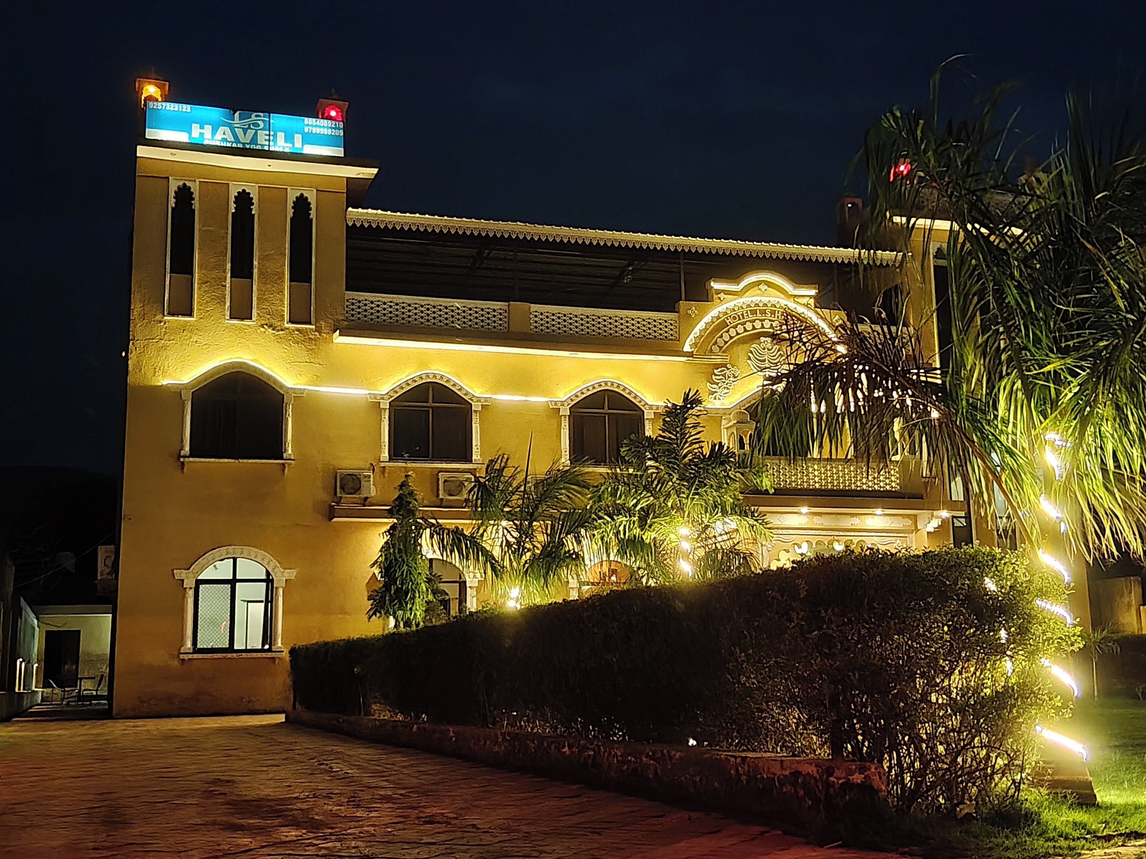 A hotel with a traditional architectural style, featuring arched windows and a central entrance with a decorative archway.