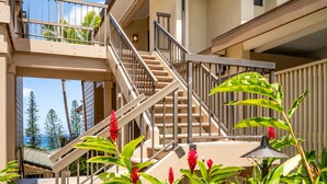 A multi-level building with a staircase, outdoor plants, and a view of the ocean. - 🏝️ Maui is Calling - Beautiful Kapalua Ocean and Golf Course View (Lahaina)