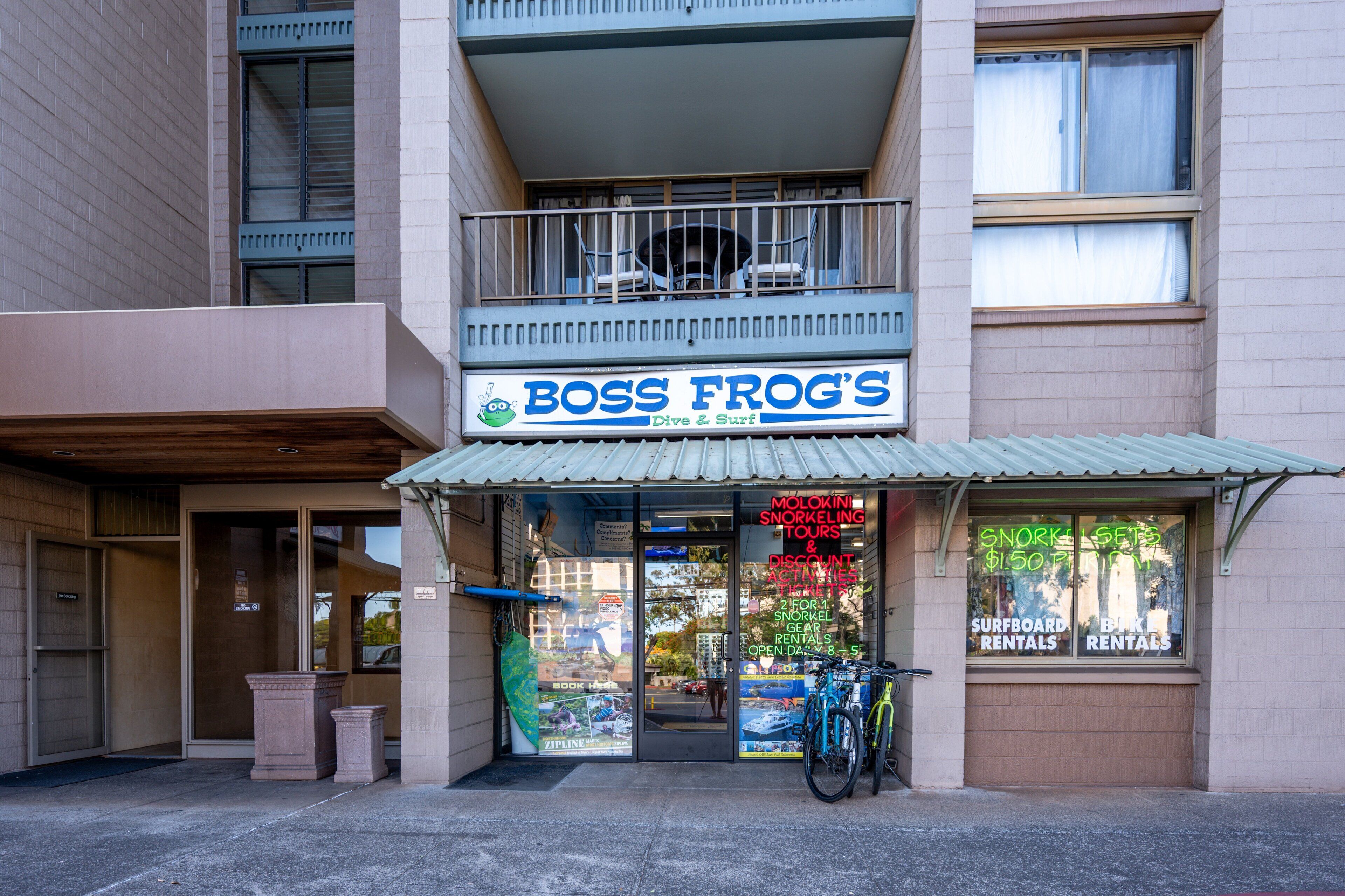 A storefront with a sign reading "BOSS FROG'S Dive & Surf".