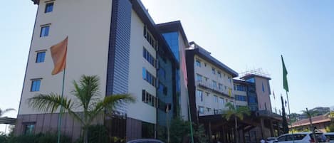 A multi-story hotel with a modern architectural design, featuring a mix of glass and solid facade elements.