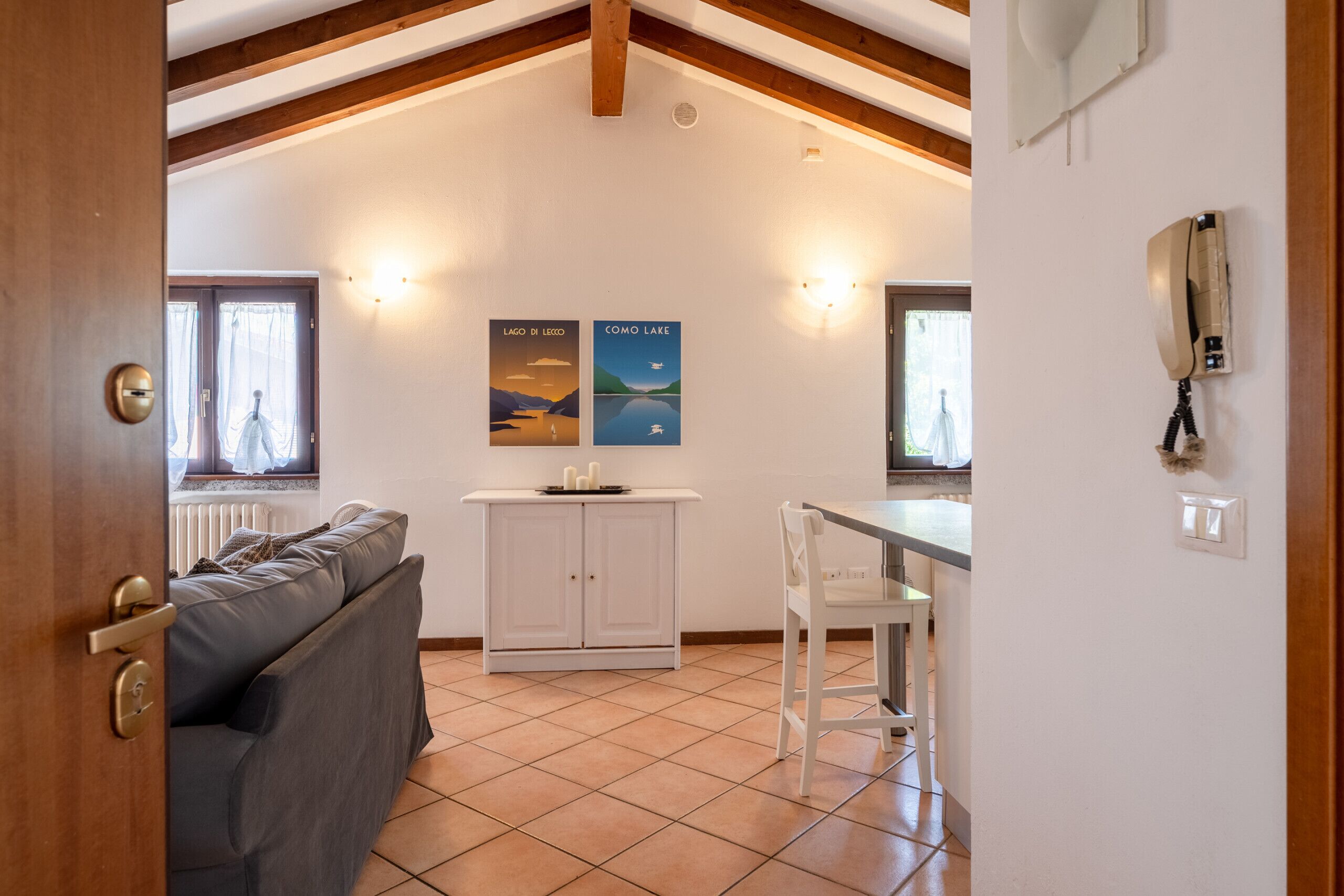A cozy room with a sofa, a dining table, and a kitchen area.
