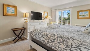 A hotel room with a bed, a TV, a desk, and a chair.