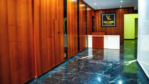 A hotel reception area with wooden paneling and a marble floor.