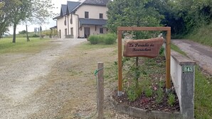 Un senyal indica 'Le Porad de Bournon', un camí de grava, una casa i una carretera.