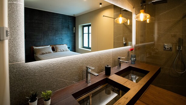 Un bagno moderno con uno specchio grande, due lavabi e una zona doccia.