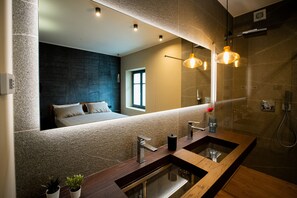 A modern bathroom with a large mirror, dual sinks, and a shower area. - KODERLE SUITE K4 - Zampa D'Orso (Brunico)