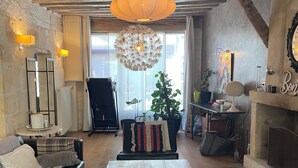 Een gezellige woonkamer met een glazen salontafel, leren bank en een groot raam.