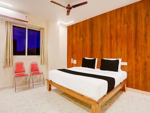A bedroom with a wooden bed frame, a ceiling fan, and a window with curtains.