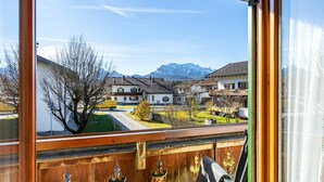 A view from a window overlooking a residential area with houses and mountains in the background.
