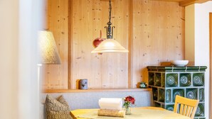 A wooden interior with a dining table, a lamp, and a decorative cabinet. - Apartment '2' with Mountain View, Balcony and Wi-Fi (Krün)