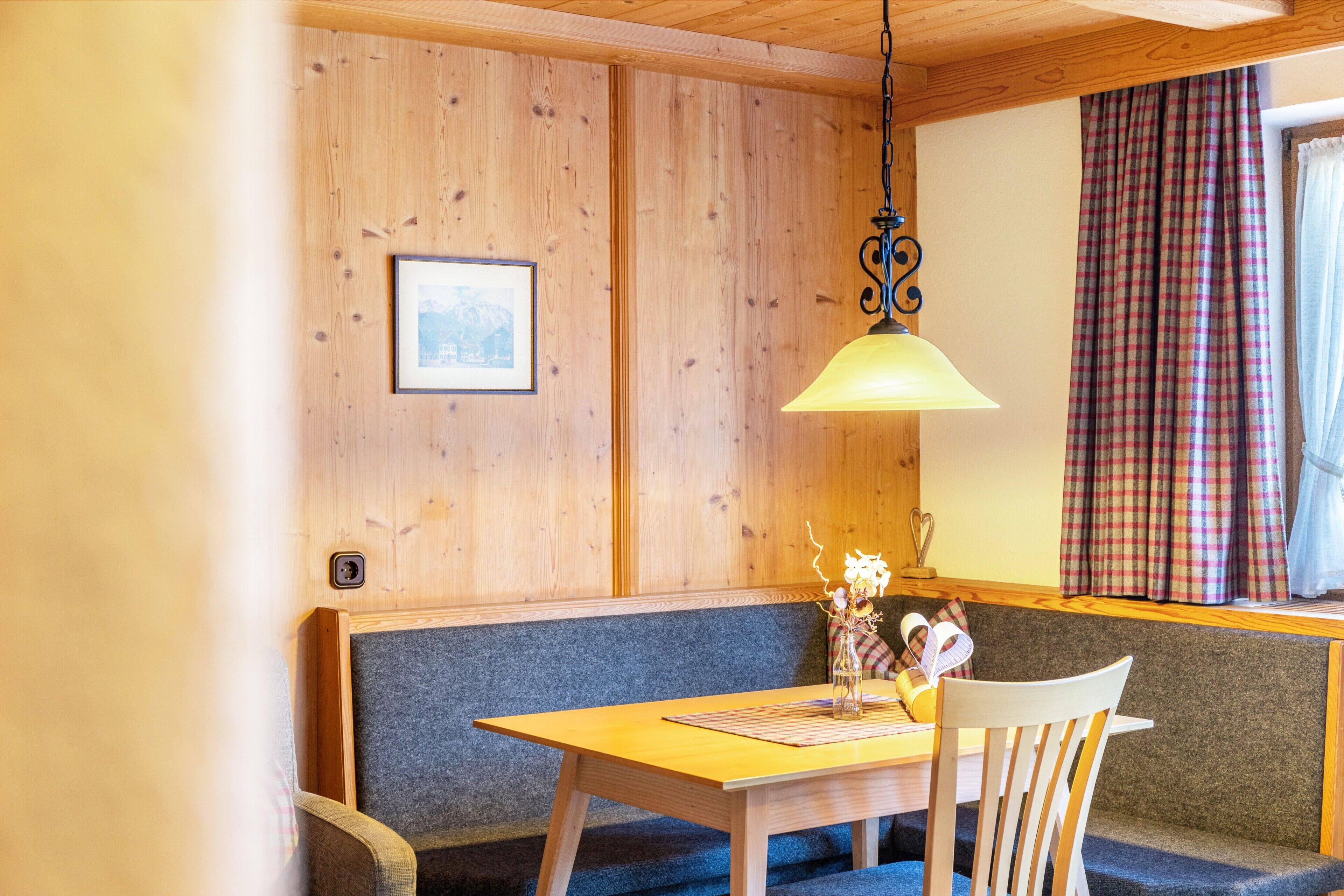 Una stanza con rivestimento in legno, un divano, un tavolo e un lampadario.