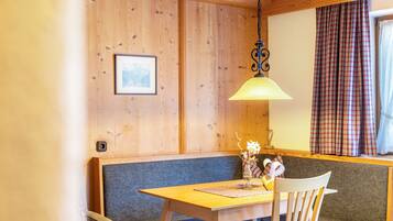 Una stanza con rivestimento in legno, un divano, un tavolo e un lampadario.