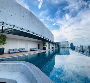 A modern building with a rooftop infinity pool, seating areas, and a city view. - Core Residence TRX Kuala Lumpur  (Kuala Lumpur)