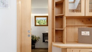 A wooden interior with a window, a plant, and a shelf with a sign. - Apartment 'Alpenglühn' with Dolomite Views, Balcony and Wi-Fi (Ritten)